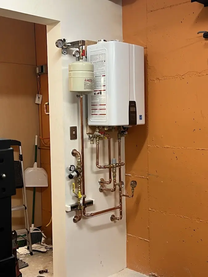 Plumbing technician inspecting water heater connections in Barnstead
